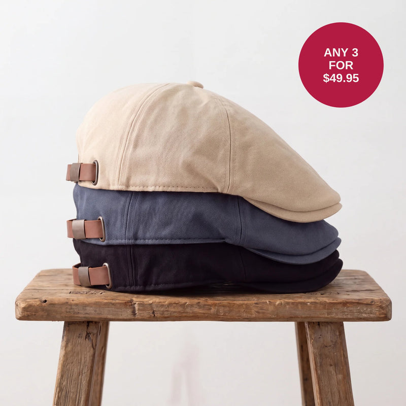 Beige, blue and black flat caps stacked