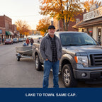 Angler by his truck and boat trailer on a small lake town main street, black flat cap
