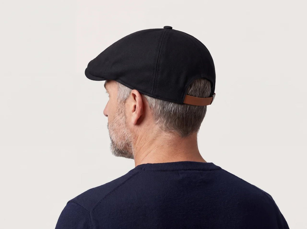 Back view of the plain black flat cap with leather strap