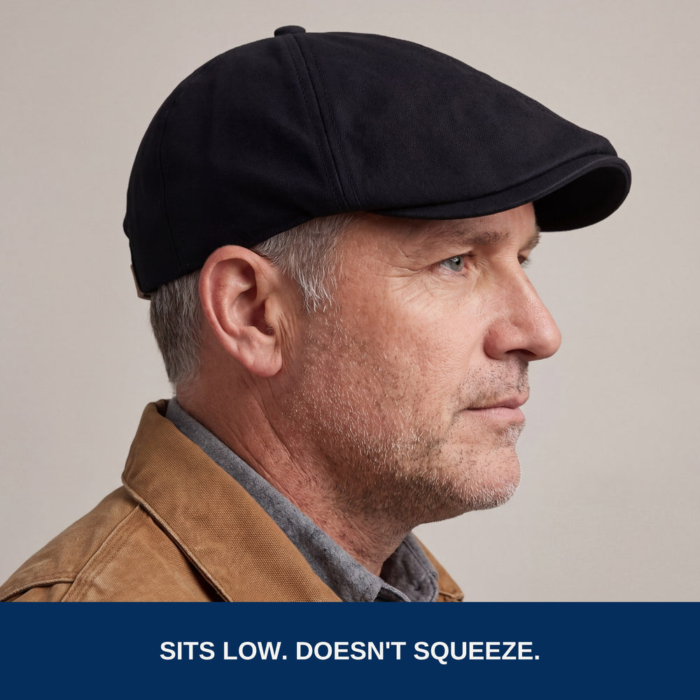 Side profile of the black flat cap worn low. Sits low, doesn't squeeze