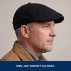 Side profile of the black flat cap worn low. Sits low, doesn't squeeze
